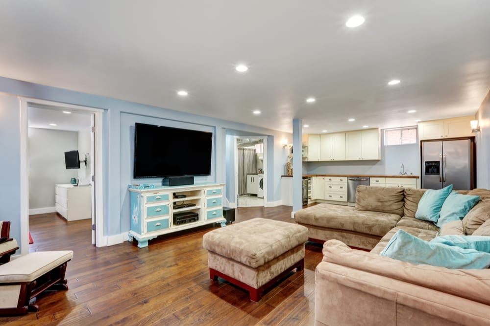 Finished basement lounge with sectional and built-in cabinetry