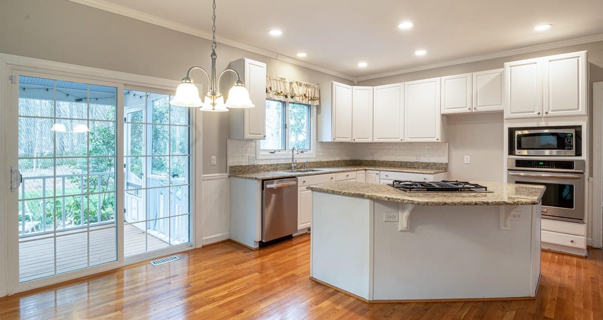 Renovated white kitchen with island and sliding glass doors